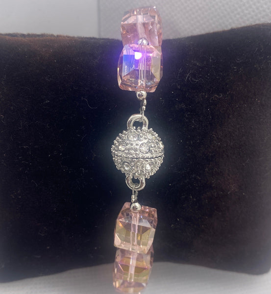 Jewelry with pink and clear beads on a black velvet cushion