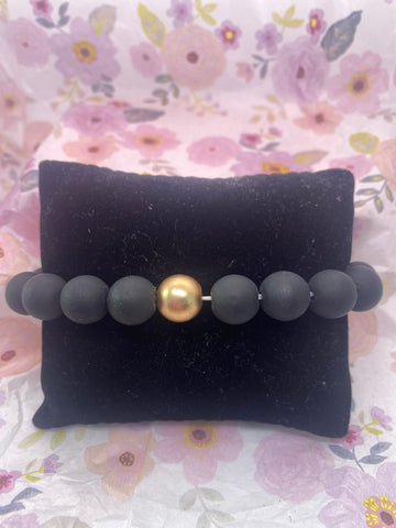 Black Clay Bead with a Gold Tone Bead Stretch Bracelet