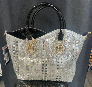 Decorative handbag with intricate design and gold accents on a dark surface