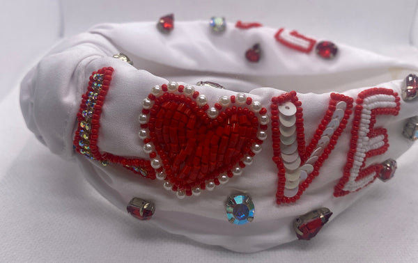 White Love headband with red and silver embellishments on a white background