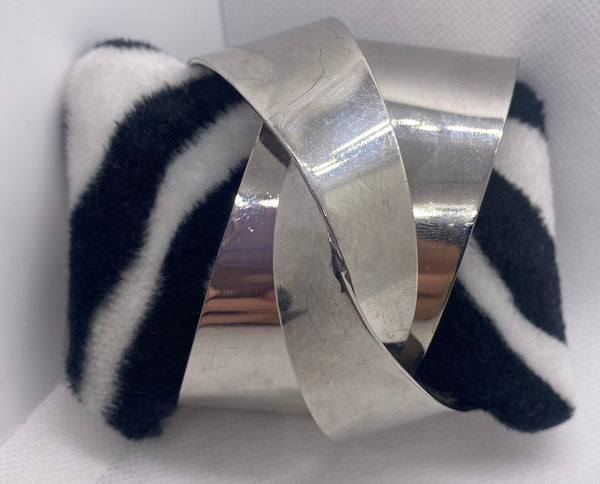 Silver cuff bracelet with zebra pattern on a white background