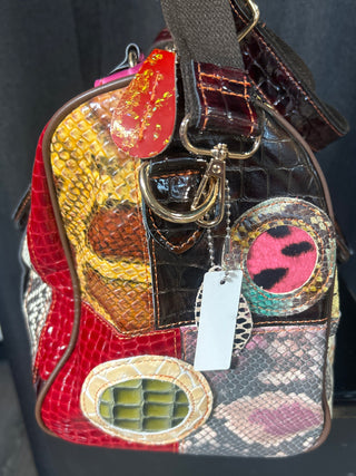 Multicolored textured handbag with decorative elements on a dark background