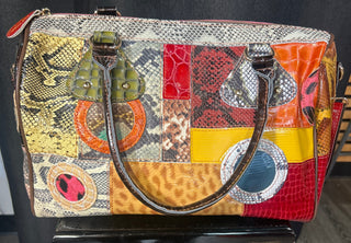 Colorful patchwork handbag with a textured handle on a black surface