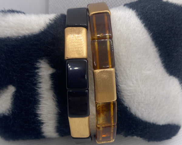 Set of bracelets on a black and white striped fabric with a white background