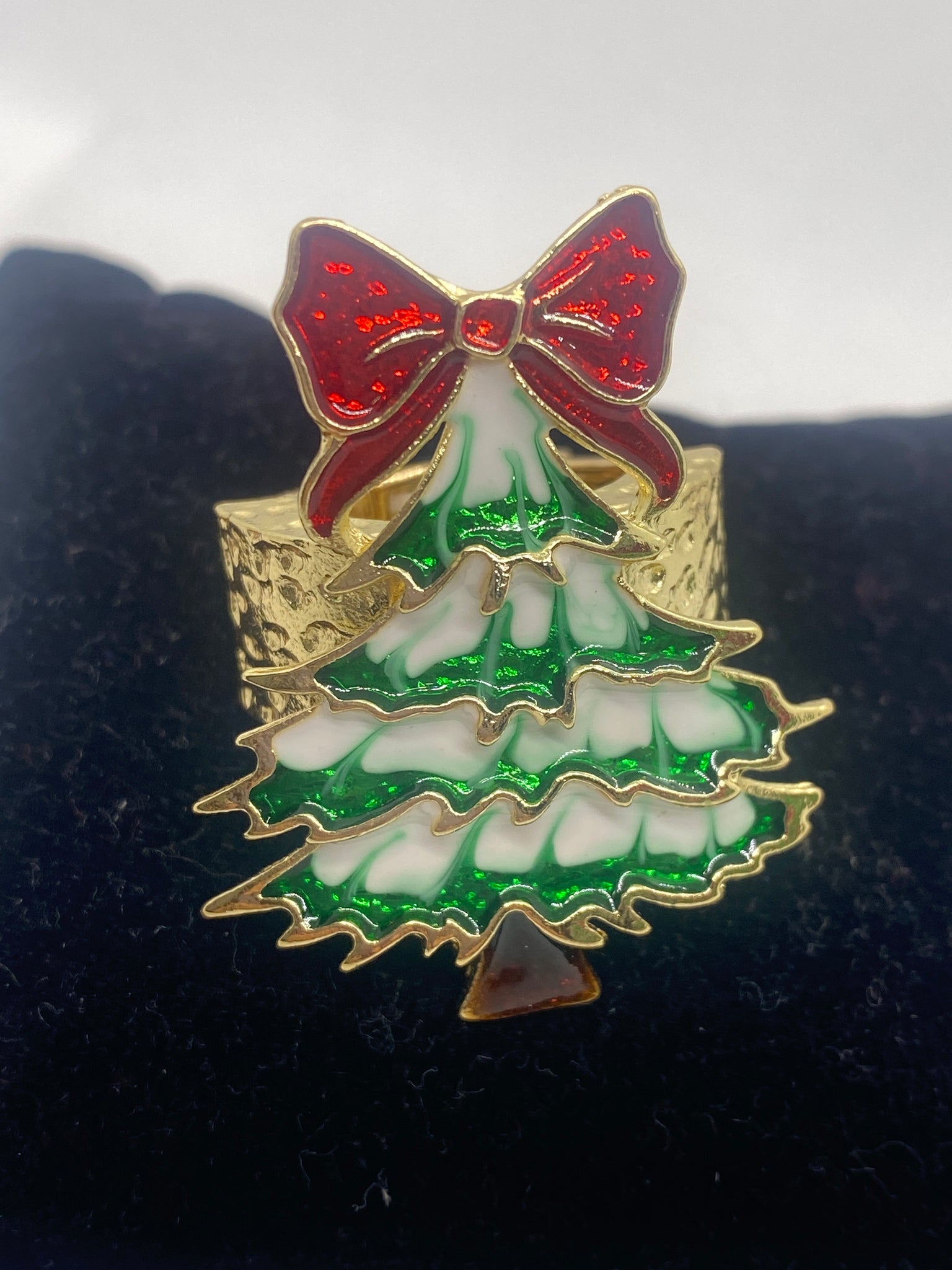 Decorative stretch Christmas Ring with red bow and green leaves on a dark background