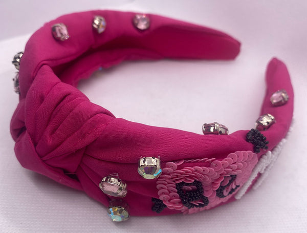 Pink headband with decorative elements on a white background