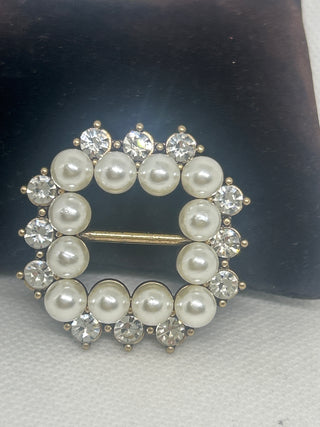 Jewelry brooch with pearls and crystals on a dark background