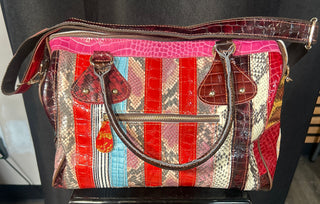 Multicolored handbag with a prominent brand logo on a dark surface