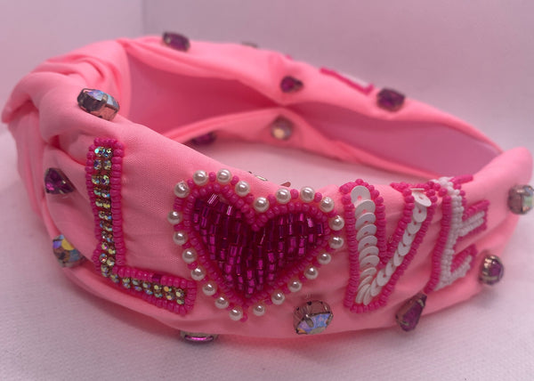 Pink Love headband with decorative elements on a white background