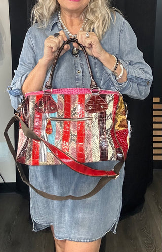 Person holding a colorful patchwork handbag with a denim dress.