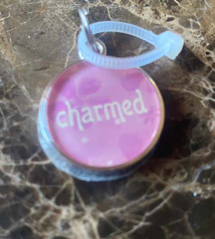 Pink  with 'charmed' text on a marble surface