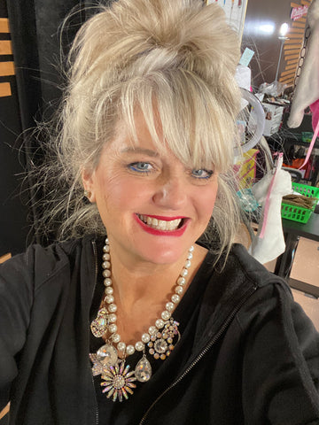 Woman with styled hair and jewelry in a casual setting