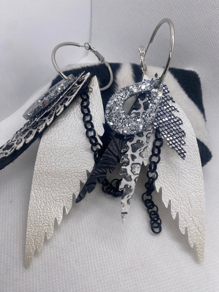 Feather-shaped earrings with chain and decorative elements on a white background