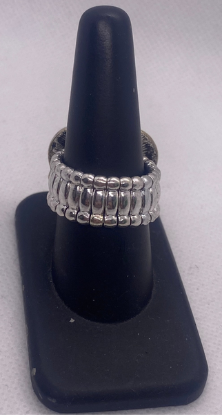 Silver ring on a black ring stand against a white background