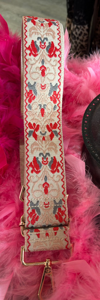 Decorative belt with intricate patterns on a pink feathered background