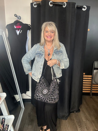 Woman posing with a handbag in a fitting room setting