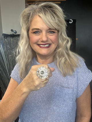 Woman holding a large decorative ring in front of her face