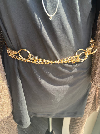 Gold chain belt on a mannequin with a plain background