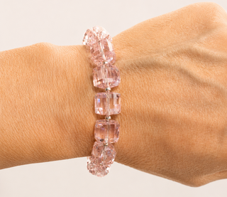 Pink crystal bracelet on a wrist against a neutral background