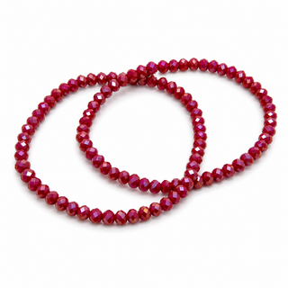 Two beaded stretch bracelets made of faceted dark red beads, arranged in overlapping loops on a plain white background.