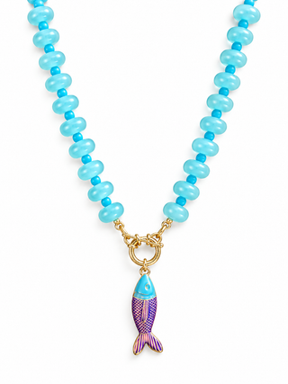 A beaded necklace featuring light blue and turquoise round beads with a gold-tone clasp and a dangling fish charm in light blue and purple enamel.