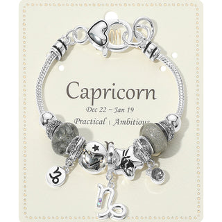 Silver bracelet with charms on a card labeled 'Capricorn'