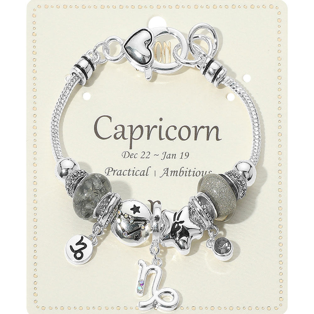 Silver bracelet with charms on a card labeled 'Capricorn'