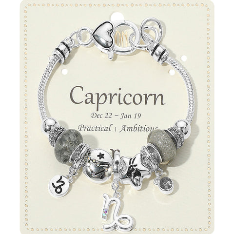 Silver bracelet with charms on a card labeled 'Capricorn'