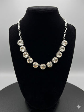 Necklace with large crystals on a black bust against a gray background