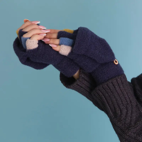 Navy blue fingerless gloves with a textured pattern worn by a person against a blue background