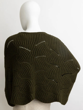 Mannequin wearing a dark green knitted poncho against a white background