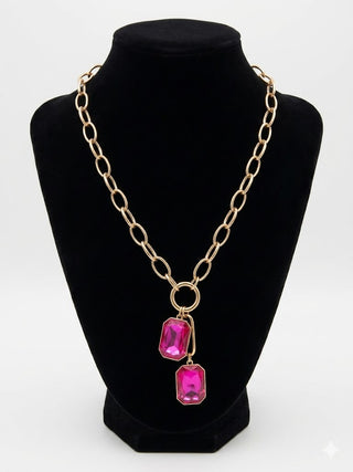 Silver chain necklace with pink gemstones on a black mannequin bust.