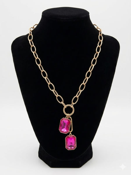 Silver chain necklace with pink gemstones on a black mannequin bust.