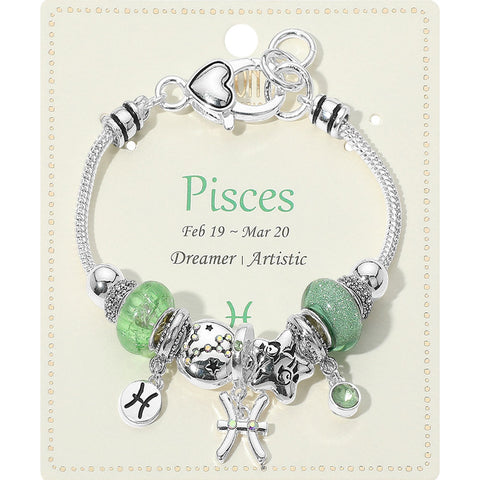 Pisces-themed bracelet with green beads and charms on a matching card